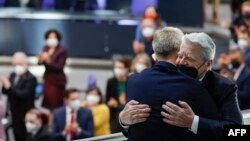 Former German President Joachim Gauck, right, embraces the Ukrainian ambassador to Berlin Andrij Melnyk as he is given standing ovations at the start of an extraordinary session of the Bundestag (lower house of parliament) on Feb. 27, 2022 in Berlin.