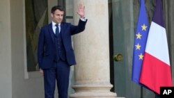 French President Emmanuel Macron waves goodbye to Georgia President Salome Zurabishvili after their talks at the Elysee Palace, Feb. 28, 2022 in Paris. 