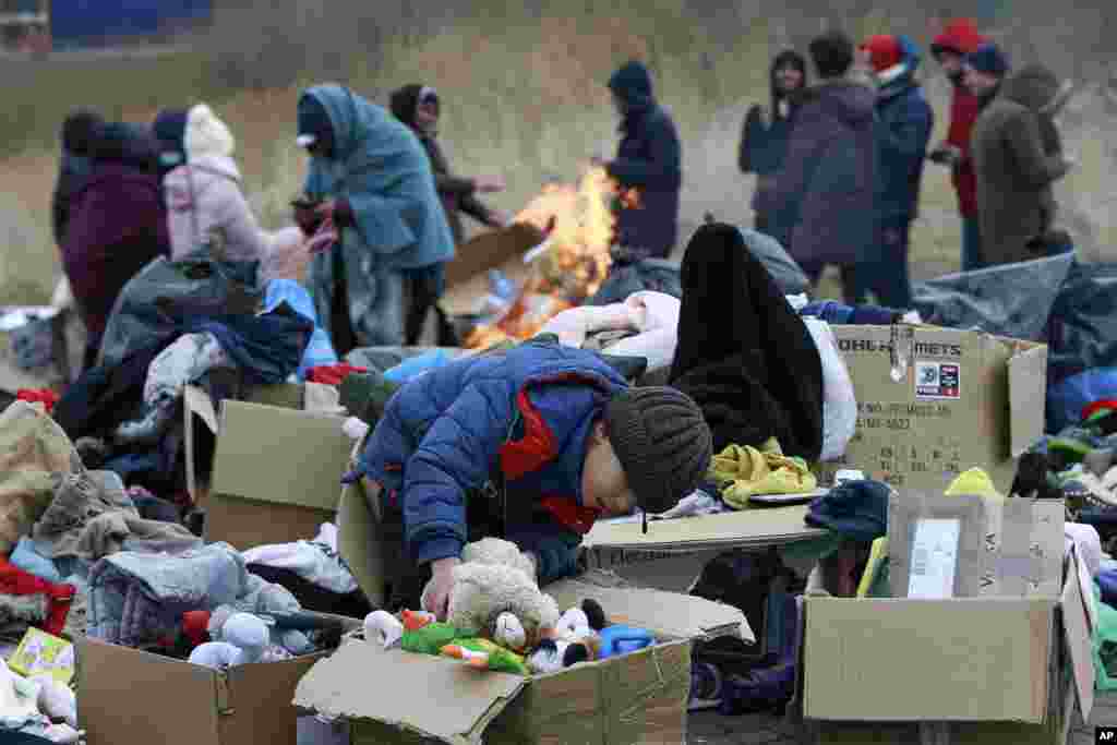 Un niño recoge juguetes cerca de un punto de donación de ropa cuando los refugiados que huyen del conflicto en Ucrania llegan al cruce fronterizo de Medyka en Polonia, el lunes 28 de febrero de 2022. (Foto AP/Visar Kryeziu)