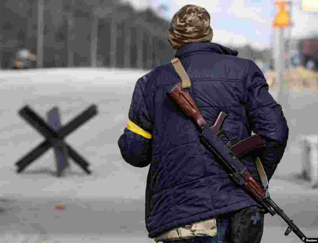 A member of the Territorial Defence Forces of Ukraine stands guard at a checkpoint on the outskirts of Kyiv, Ukraine, Feb. 27, 2022. 