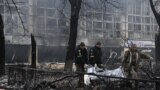 Police officers move the bodies of passersby killed in yesterday's airstrike that hit Kyiv's main television tower in Kyiv, Ukraine, March 2, 2022. 