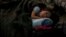 A child from Ukraine rests in a tent, part of a humanitarian center for refugees at the Moldovan-Ukrainian border, in Palalanca, Moldova, Feb. 25, 2022. Thousands of Ukrainians are fleeing from war by crossing their borders to the west in search of safety.