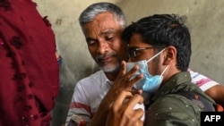 A man embraces his son, who was evacuated from Ukraine, after his arrival on a special flight at the airport in Chennai, India, on Feb. 27, 2022.