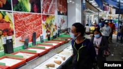 Customers wearing face masks walk past empty shelves at a wet market, ahead of mass coronavirus disease (COVID-19) testing, in Hong Kong, March 1, 2022. 