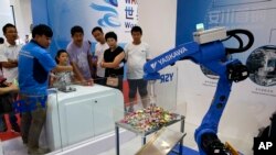 2017年8月23日，参展商在北京亦创国际会展中心的世界机器人大会上展示中国制造的工业机器人。（美联社照片）