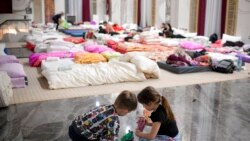 Children who fled the conflict from neighboring Ukraine play on the floor of an event hall in a hotel offering shelter in Siret, Romania, Feb. 26, 2022.