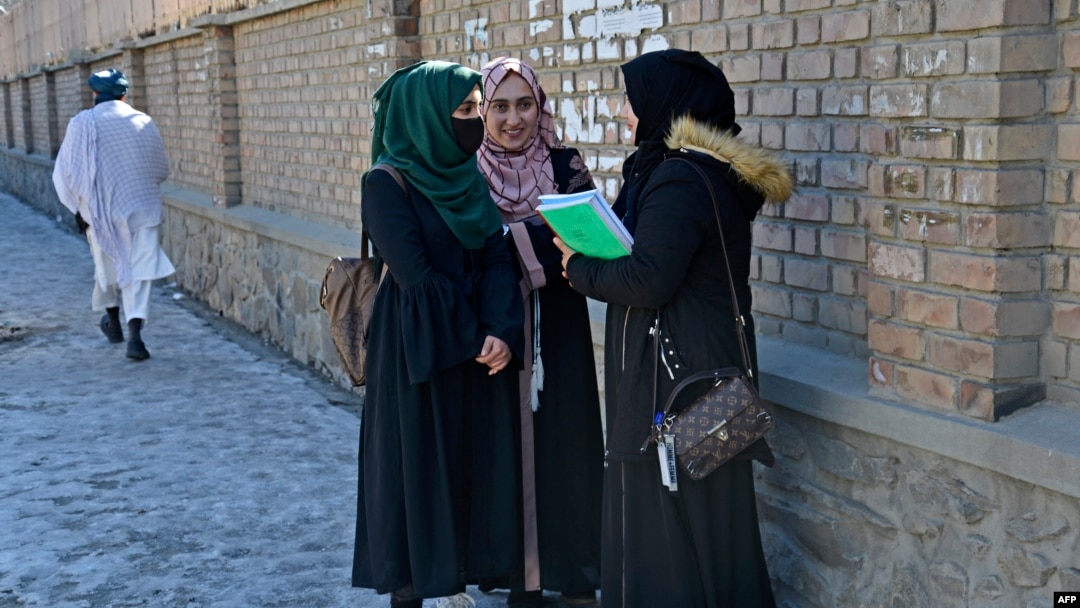 Students stand along a pathway near the Kabul University after it was reopened in Kabul, Afghanistan, on Feb. 26, 2022.