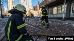 Firefighters work at the site where a residential building was hit Saturday morning, blowing out three floors in an area not far from downtown Kyiv, in Ukraine, Feb. 25, 2022.