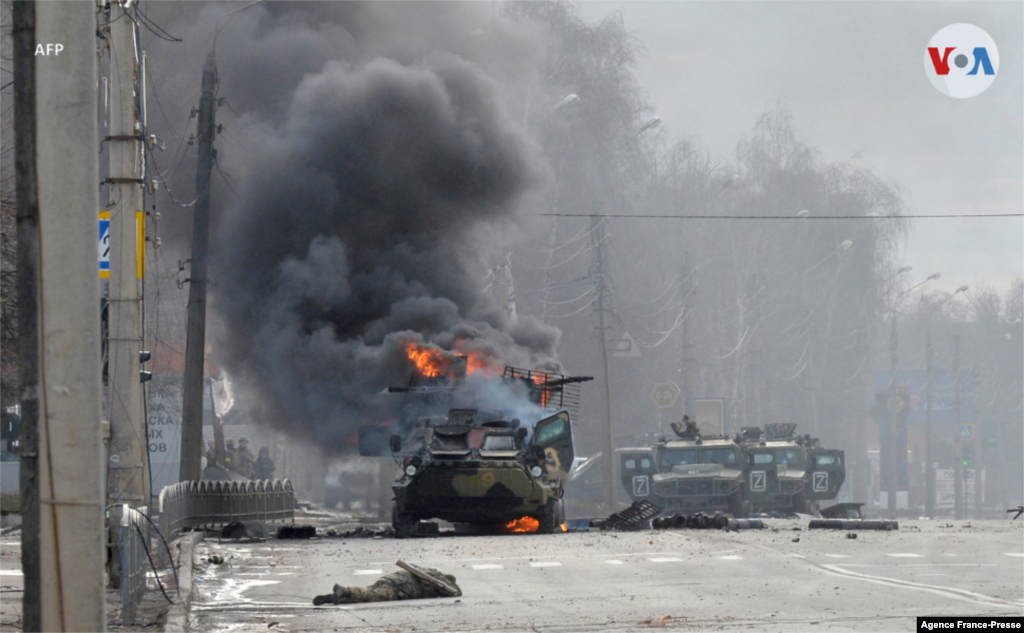 Un soldado no identificado muerto y un vehículo blindado ruso ardiendo, resultado de uno de los enfrentamientos entre fuerzas rusas y ucranianas en Járkov.
