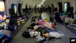 FILE - People gather in the Kyiv subway, using it as a bomb shelter, in Kyiv, March 2, 2022.