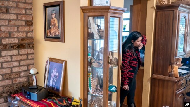 Mary Risling stands near a photo of her missing sister, Emmilee Risling, at the family home on Jan. 21, 2022, in McKinleyville, California.