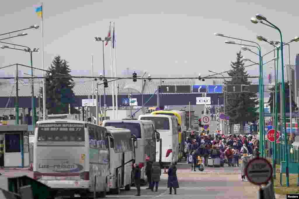 People fleeing the Russian invasion in Ukraine stand in line at the border crossing for entry into Poland, in Shehyni, Feb. 27, 2022. 