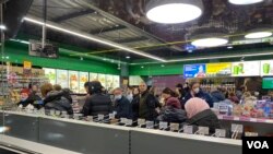 Porodice kupuju gorivo, hranu i druge stvari u prodavnici na benzinskoj pumpi prepunoj ljudi koji beže od ruske invazije, u Ukrajini, 27. februara 2022.