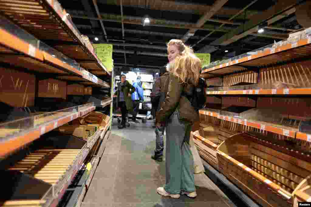 A woman looks at empty shelves of bread after the curfew was lifted as Russia&#39;s invasion of Ukraine continues, in Kyiv, Ukraine, Feb. 28, 2022.