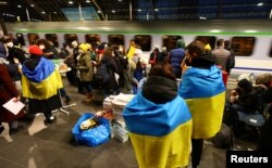 Relawan menunggu pengungsi saat kereta api dari Polandia tiba di stasiun kereta api pusat Berlin, menyusul invasi Rusia ke Ukraina, di Berlin, Jerman, 28 Februari 2022. (Foto: REUTERS/Fabrizio Bensch)