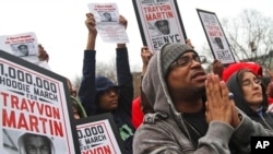 FILE - Demonstrators pray during the Million Hoodie March in Union Square, March 21, 2012, in New York. 