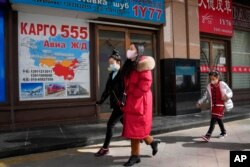 Residents past near shops at a mall, also known as Russia Market, for Russian traders on Feb. 26, 2022, in Beijing.