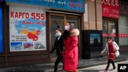 Residents past near shops at a mall, also known as Russia Market, for Russian traders on Feb. 26, 2022, in Beijing. 