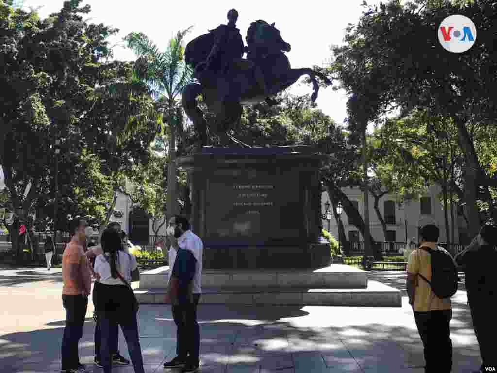 Grupo escucha explicación frente a la estatua ecuestre del Libertador Simón Bolívar en la Plaza Bolívar de Caracas. Febrero de 2022. Foto: Carolina Alcalde - VOA.