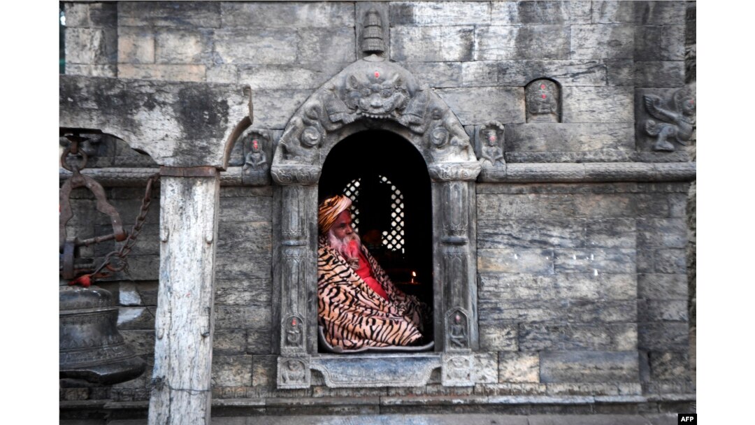 Seorang Sadhu atau orang suci Hindu duduk di kuil Pashupatinath saat berlangsungnya festival Maha Shivaratri di Kathmandu, 1 Maret 2022. (PRAKASH MATHEMA / AFP)