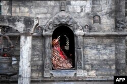 Seorang Sadhu atau orang suci Hindu duduk di kuil Pashupatinath saat berlangsungnya festival Maha Shivaratri di Kathmandu, 1 Maret 2022. (PRAKASH MATHEMA / AFP)