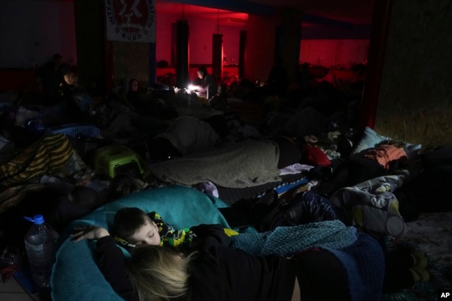 People sleep in the improvised bomb shelter in a sports center, which can accommodate up to 2000 people, in Mariupol, Ukraine, Feb. 27, 2022. (AP Photo/Evgeniy Maloletka)