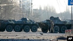 Un soldado pasa junto a vehículos blindados ucranianos que forman una barricada en una calle de Kiev, Ucrania, el 26 de febrero de 2022. (AP Foto/Efrem Lukatsky)NIA-INVASIÓN