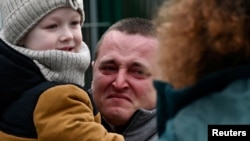 在俄罗斯大举进攻乌克兰后，一位男子抱着小孩从乌克兰抵达斯洛伐克。(2022年2月25日)