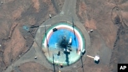 In this satellite photo from Maxar Technologies, trucks and other equipment surround a scorched launch pad at Iran's Imam Khomeini Spaceport in rural Semnan province, Feb. 27, 2022.