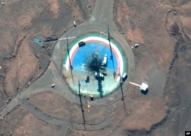 Foto satelit dari Maxar Technologies memperlihatkan truk, dan peralatan lainnya mengelilingi landasan peluncuran yang hangus di Pelabuhan Luar Angkasa Imam Khomeini Iran, 27 Februari 2022. (Foto: via AP)