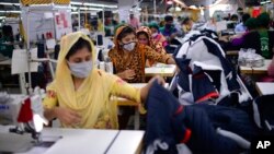 বাংলাদেশের রাজধানী ঢাকার উপকণ্ঠে একটি গার্মেন্টস কারখানায় কাজ করছেন কর্মীরা। ৯ আগস্ট, ২০২১। (ফাইল ছবি) 