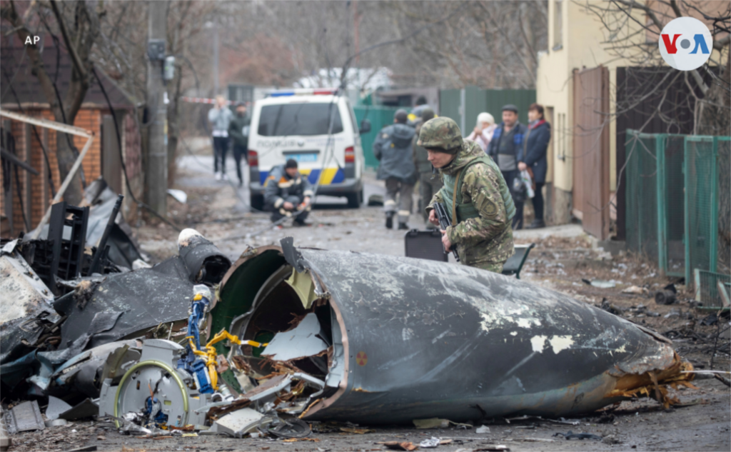 Un soldado del ejército de Ucrania inspecciona los fragmentos de un avión en Kiev.