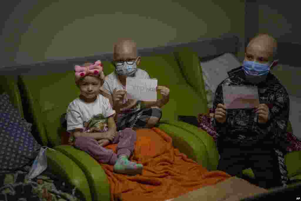 Pacientes de oncología sostienen hojas de papel con las palabras &quot;Alto a la guerra&quot; en una base utilizada como refugio antiaéreo en el hospital infantil de Okhmadet, en el centro de Kiev, Ucrania, el lunes 28 de febrero de 2022. (Foto AP/Emilio Morenatti)