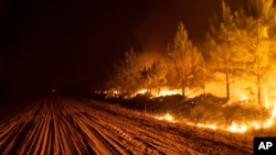 A wildfire consumes a forest near Ituzaingo in the Corrientes province of Argentina, Feb. 19, 2022. Local authorities attributed the fires to the burning of pastures for cattle ranching, which has been prohibited since December. (AP Photo/Rodrigo Abd, File)