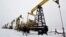 FILE - A worker walks past pump jacks at an oil field east of Izhevsk, Russia, Dec. 7, 2007. 