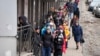 People stand in line to withdraw U.S. dollars and Euros from an ATM in St. Petersburg, Russia, Feb. 25, 2022.