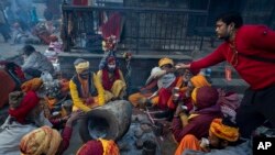 Seorang sukarelawan menyajikan teh untuk orang-orang suci selama festival Mahashivarati di kuil Pashupatinath di Kathmandu, Nepal, Selasa, 1 Maret 2022. (AP Photo/Niranjan Shreshta)