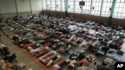 FILE - Hundreds of beds are placed inside a sports hall to accommodate Ukrainian refugees fleeing Russian invasion at the border crossing town of Medyka, Poland, March 1, 2022.