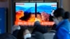 People watch a TV showing a file image of North Korea's missile launch during a news program at the Seoul Railway Station in Seoul, South Korea, Feb. 27, 2022. 