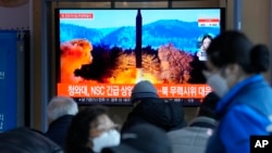 People watch a TV showing a file image of North Korea's missile launch during a news program at the Seoul Railway Station in Seoul, South Korea, Feb. 27, 2022.