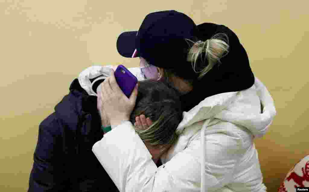 People from Ukraine comfort each other at a refugee shelter, after Russia launched a massive military operation against Ukraine, in Tiszabecs, Hungary.