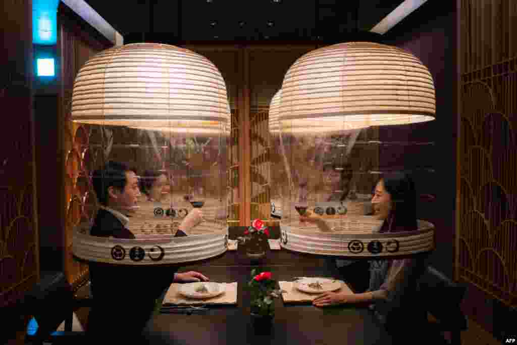 Staff members from the Hoshinoya Tokyo hotel demonstrate the &quot;Lantern Dining Experience&quot;, where lanterns made by Kojima Shoten - a shop in Kyoto - are used to shroud diners for mask-free dining amid the Covid-19 pandemic, at the hotel in Tokyo, Japan.