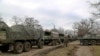 A convoy of military trucks remains parked on a street in Mykolaivka, Donetsk region, territory controlled by pro-Russian militiamen, Feb. 27, 2022, in eastern Ukraine.