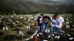 Kerabat Luis Enrique Rodriguez, yang meninggal karena COVID-19, mengunjungi tempat ia dimakamkan di sebuah bukit di Cagar Alam El Pajonal de Cogua, di Cogua, utara Bogota, Kolombia, 25 Oktober 2021.