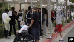 지난 22일 미국 로스엔젤레스주 캘리포니아의 병원 앞에 설치된 선별진료소에 시민들이 마스크를 착용한 채 줄 서 있다. 