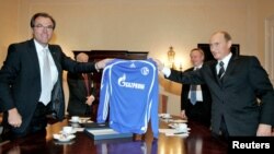 Foto de arquivo: Clemens Toennies (esq), presidente do conselho de supervisão do clube alemão da Bundesliga, Schalke 04, e Presidente russo Vladimir Putin seguram uma camisola do Schalke 04 com o logo da companhia russa Gazprom.