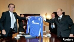 FILE PHOTO: Clemens Toennies (L), chairman of the supervisory board of the German Bundesliga soccer club Schalke 04, and Russian President Vladimir Putin hold a Schalke 04 jersey bearing the logo of Russian gas giant Gazprom.