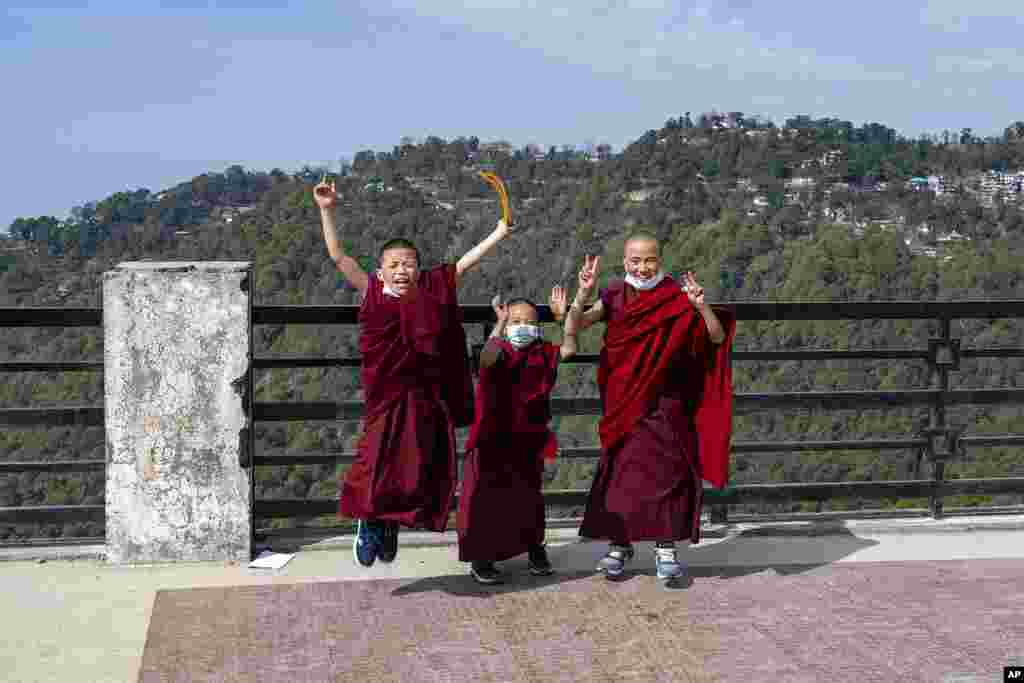 Novice Buddhist nuns pose as a senior nun, not pictured, takes a photo on her mobile phone in Dharmsala, India.