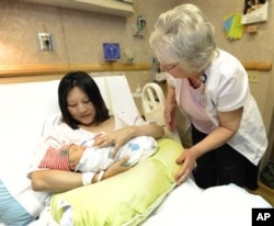 FILE -- A new mother receives breastfeeding advice from a lactation consultant at St. Joseph Hospital in Denver, Colorado.