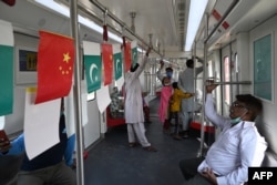 FILE - Passengers ride in a newly built Orange Line Metro Train, a project planned under the China-Pakistan Economic Corridor, a day after an official opening in the eastern city of Lahore, Oct. 26, 2020.